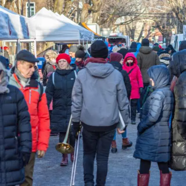 Crowd at a Christmas market upscaled with AI, resolving faces, fabric, and stall detail from a compressed phone photo before enhancement and upscaling