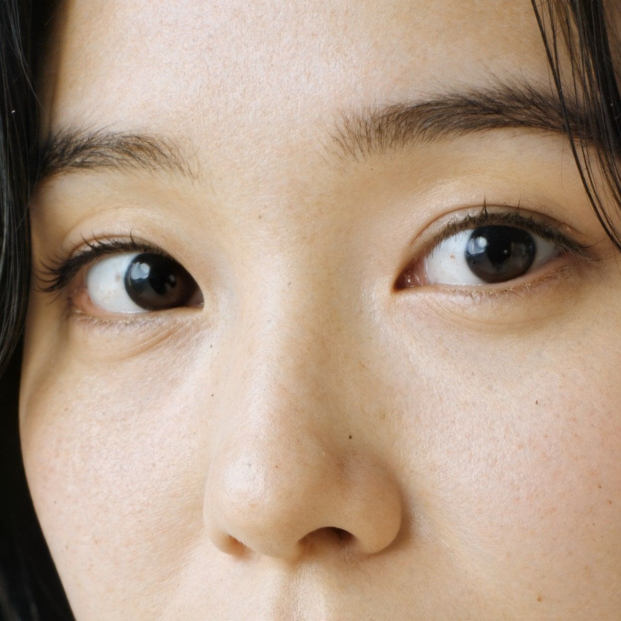 Extreme close-up of an Asian woman's eyes, highlighting improved sharpness, clarity, and intricate details post-upscaling. after enhancement and upscaling