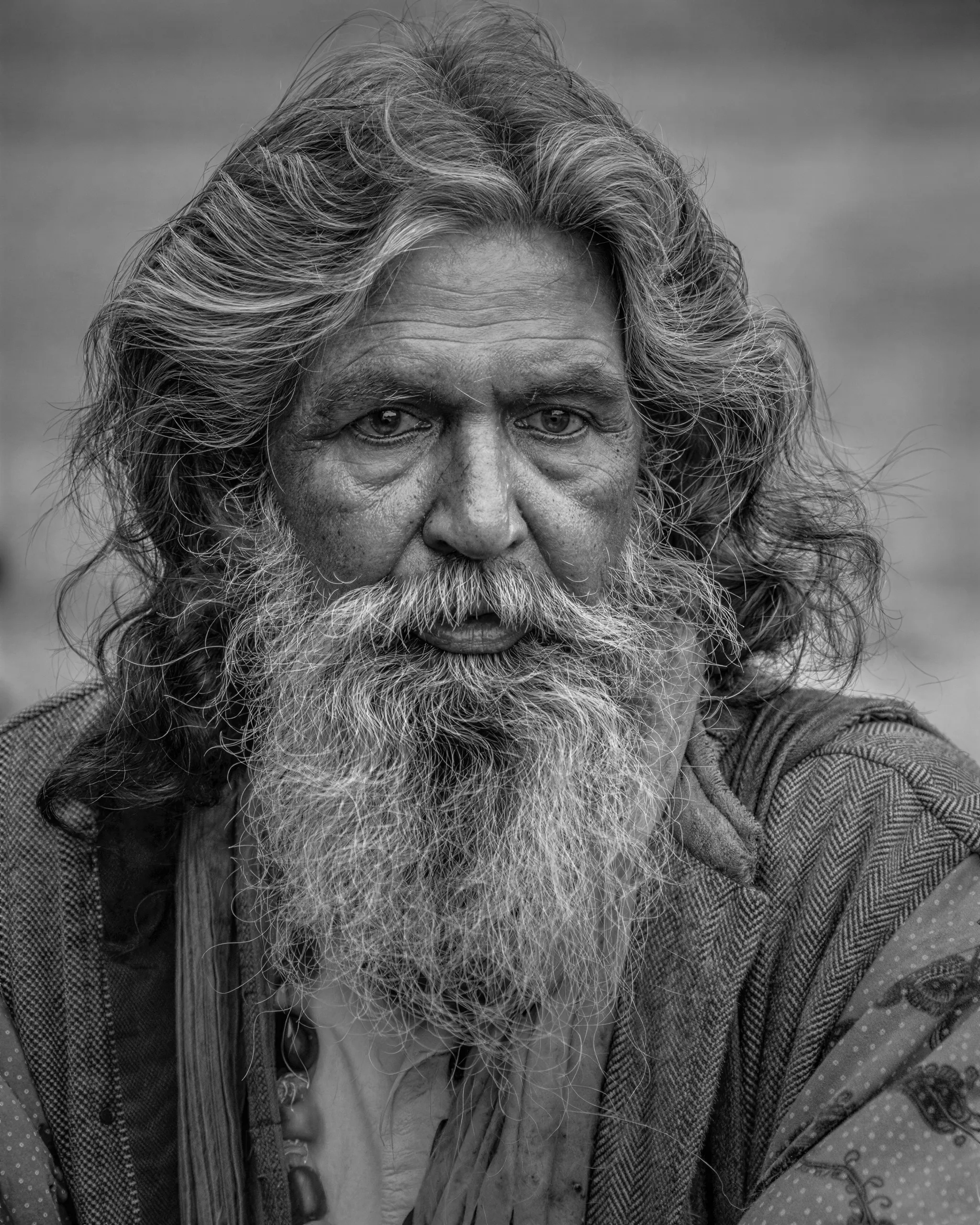 Black-and-white portrait of a bearded man restored from a blurred, compressed copy, with beard and skin detail recovered after enhancement and upscaling